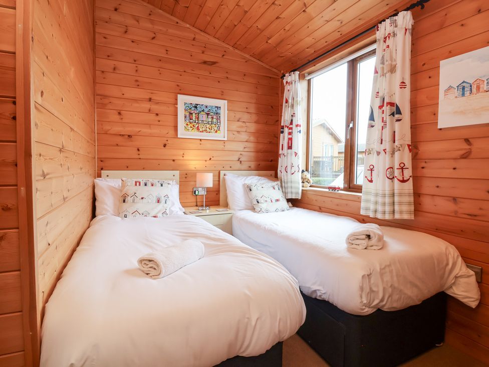 A bedroom with two beds and a window at Ocean Terrace 28 in Ilfracombe