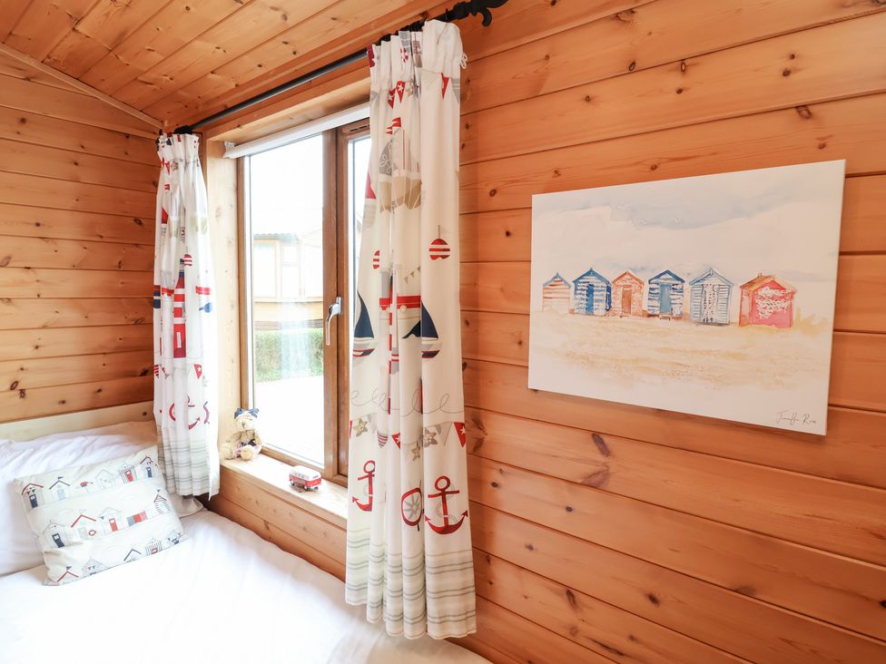 A bedroom with wooden walls and a window at Ocean Terrace 28 Ilfracombe