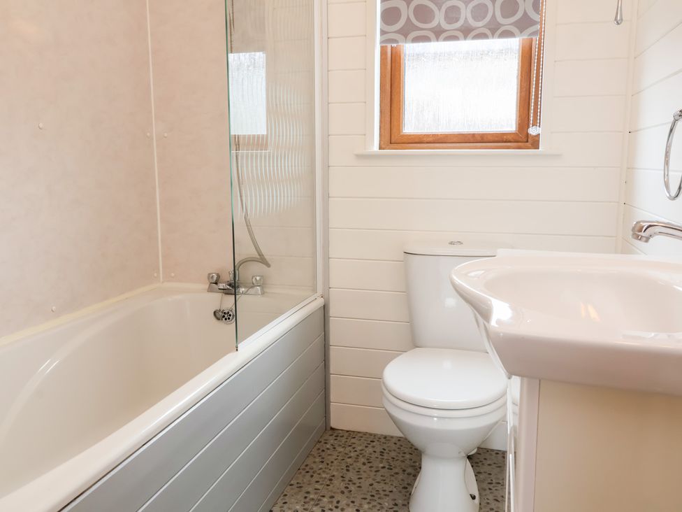 A bathroom with a bathtub, toilet, and sink at Ocean Terrace 28 Ilfracombe