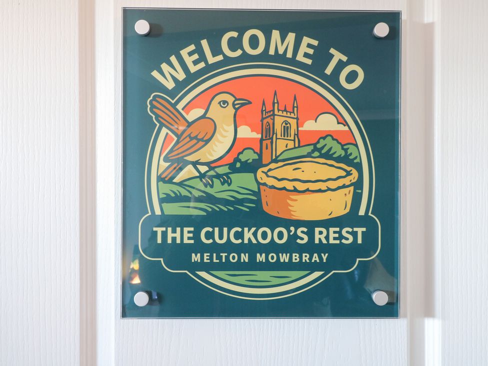 A welcome sign featuring a bird and a church at The Cuckoo's Rest in Melton Mowbray