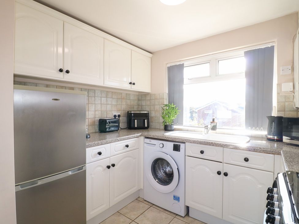 A kitchen with appliances including a fridge, washing machine, and sink at The Cuckoo's Rest in Melton Mowbray