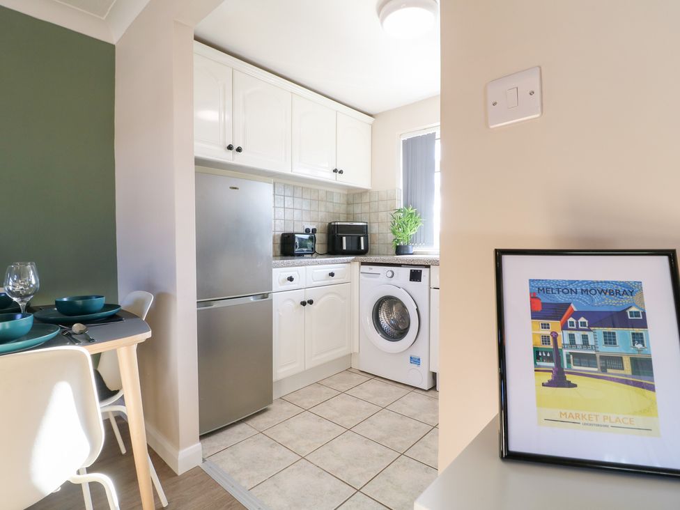 A kitchen with appliances and dining setup at The Cuckoo's Rest in Melton Mowbray