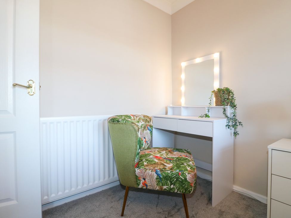 A dressing room with a chair and a mirror at The Cuckoo's Rest in Melton Mowbray