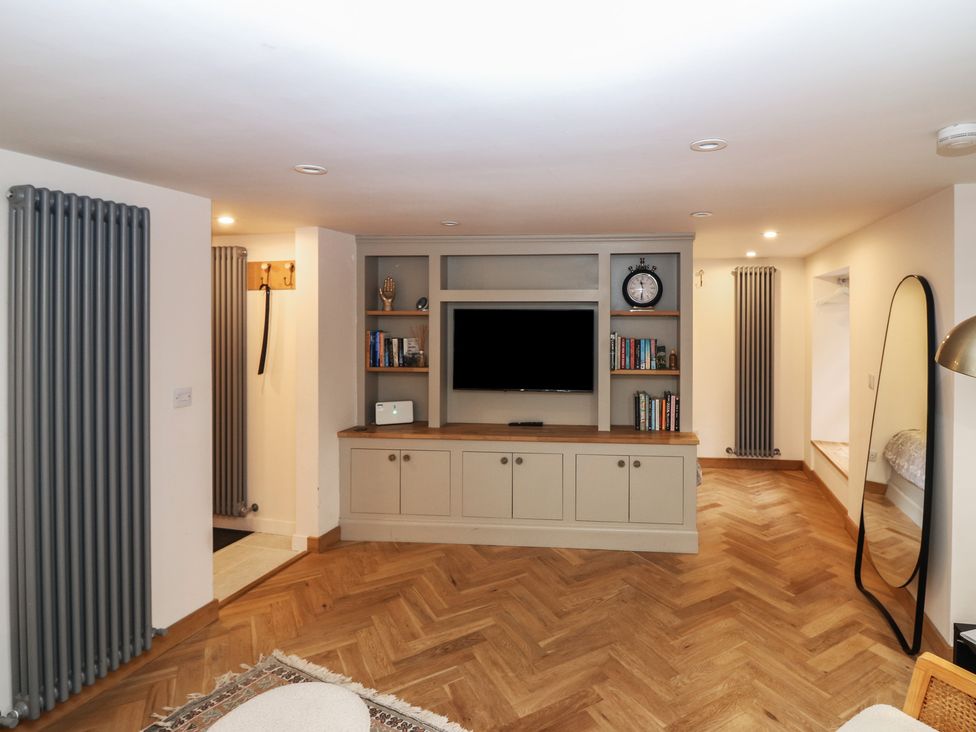 A living room with a television and shelves at 2 East Port in Melrose