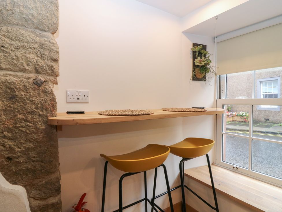 A kitchen with bar stools and a window at 2 East Port in Melrose