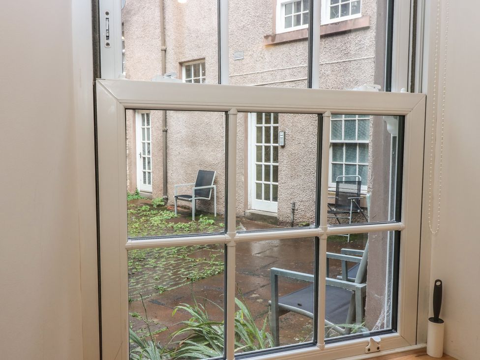 A window view of chairs and courtyard at 2 East Port in Melrose