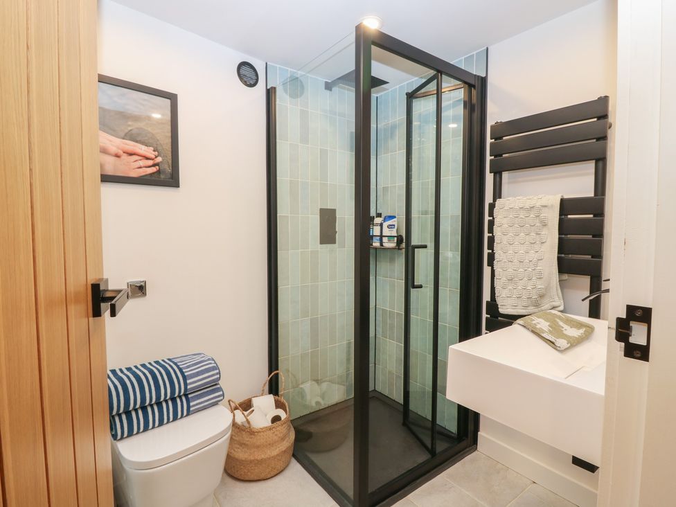 A bathroom with a shower, sink, toilet and towel rack at 2 East Port, Melrose