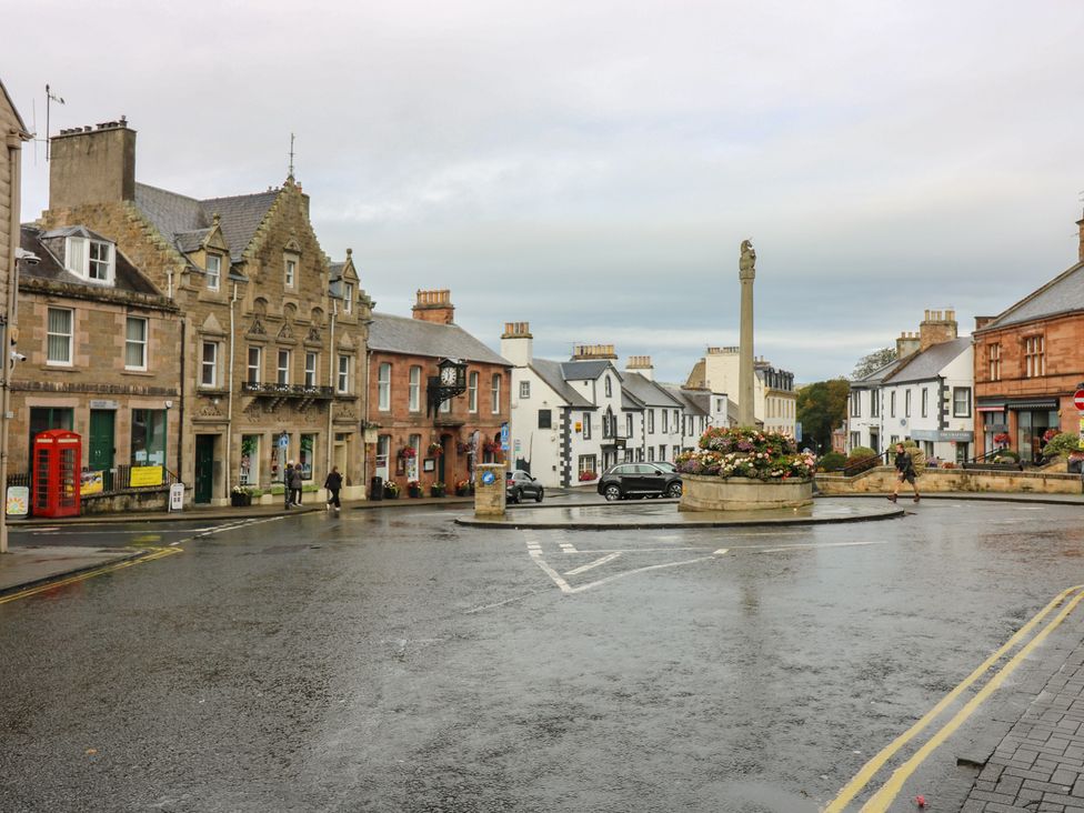 A street view of a town square with a roundabout and shops at 2 East Port in Melrose
