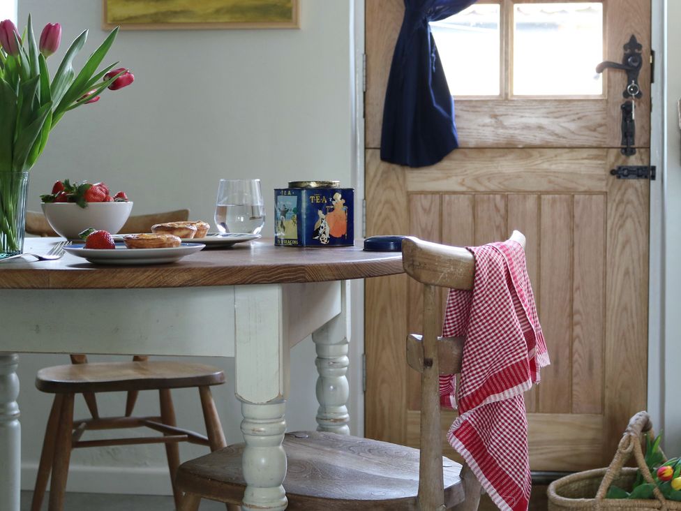 A kitchen with a table set up with food and flowers at The Old Post Box in 