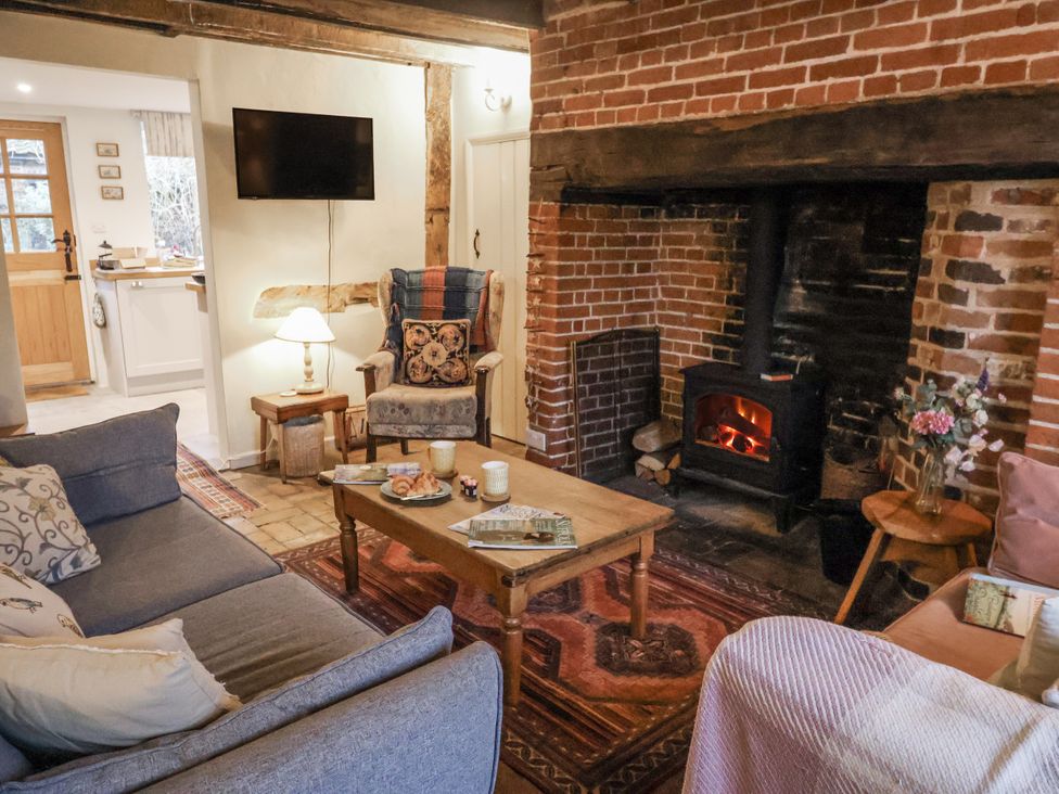 A living room with a sofa and fireplace at The Old Post Box in Halesworth