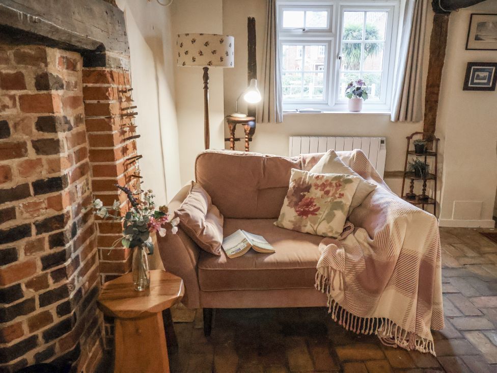 A living room with a sofa and fireplace at The Old Post Box in Halesworth