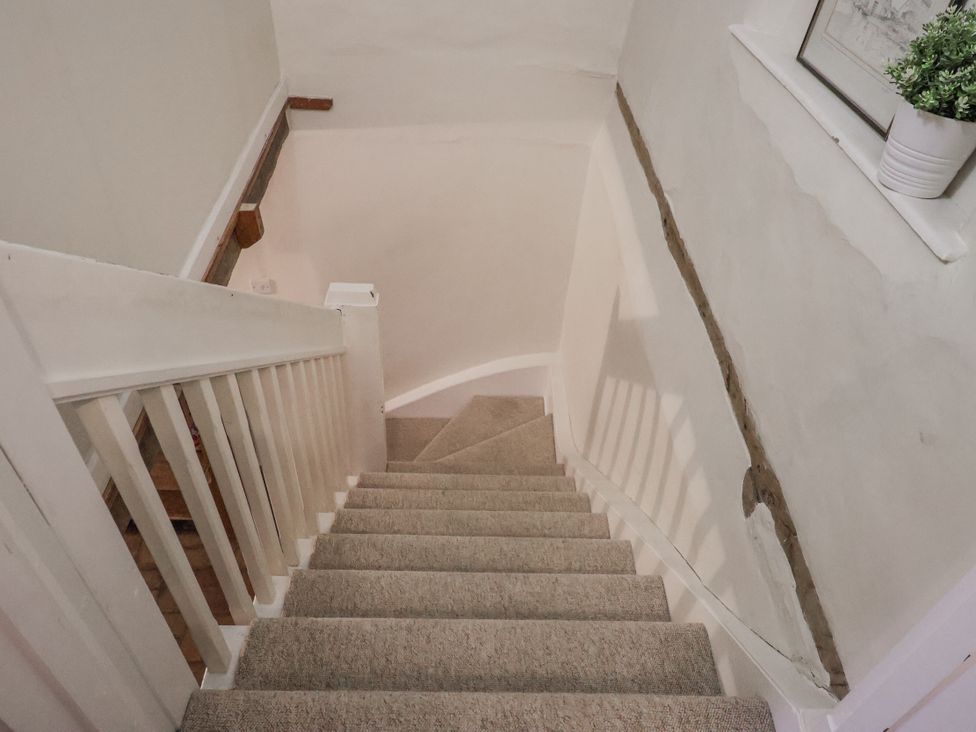 A staircase with carpet and a planter at The Old Post Box in Halesworth