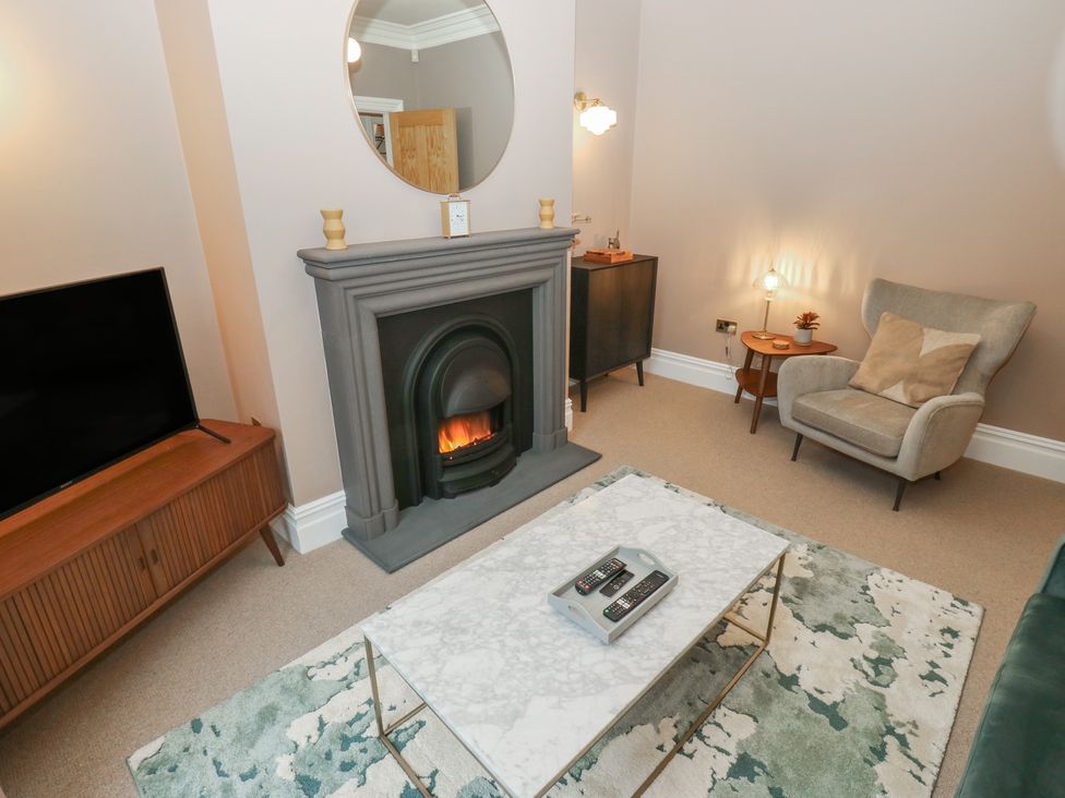 A living room with a fireplace and a coffee table at Fairfield House in Almondbury