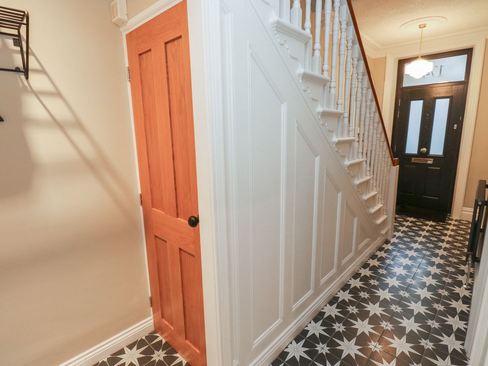 A hallway with a staircase and door at Fairfield House in Almondbury