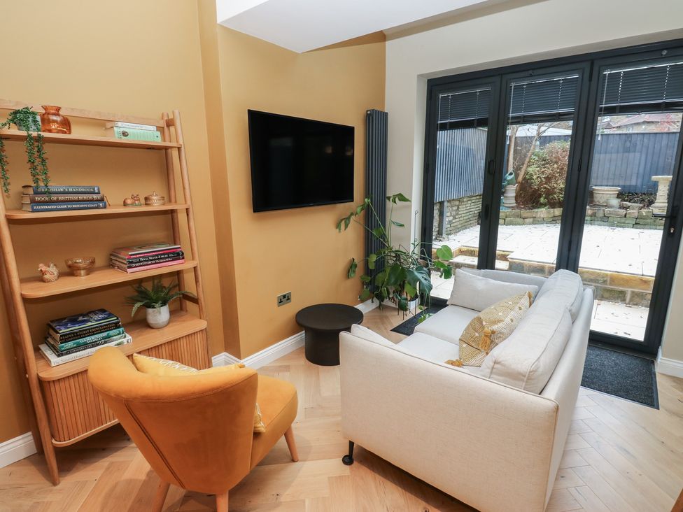 A living room with a shelf and a television at Fairfield House in Almondbury