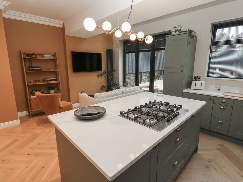 A kitchen with an island and gas stove at Fairfield House in Almondbury