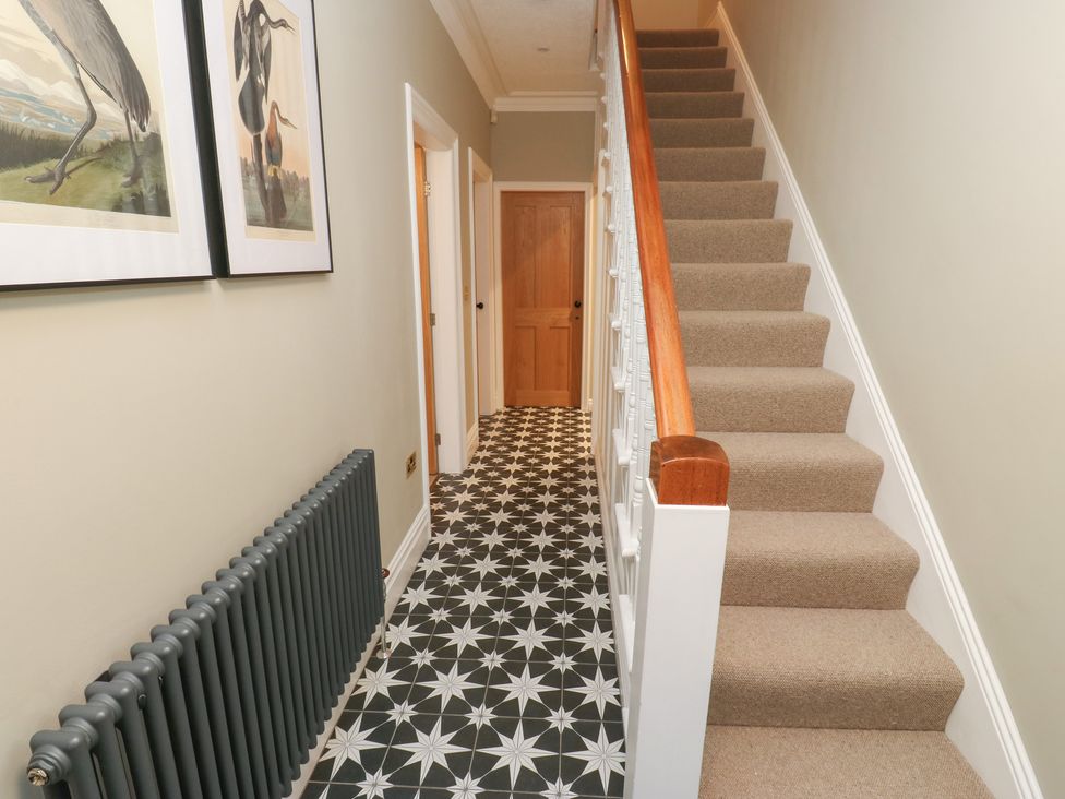 A hallway with a staircase and a radiator at Fairfield House in Almondbury