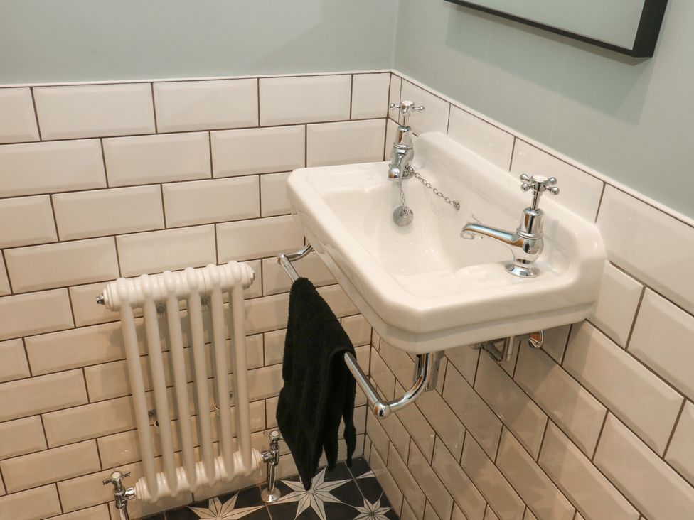 A bathroom with a sink and radiator at Fairfield House in Almondbury