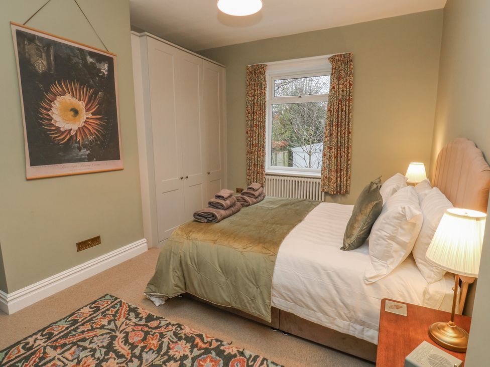 A bedroom with a bed and wardrobe at Fairfield House in Almondbury