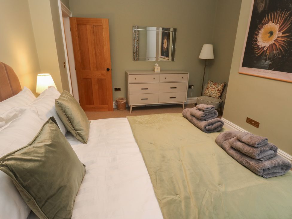 A bedroom with a bed and a wardrobe at Fairfield House in Almondbury