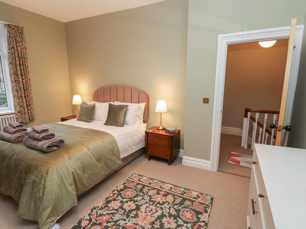 A bedroom with a bed and nightstand at Fairfield House Almondbury