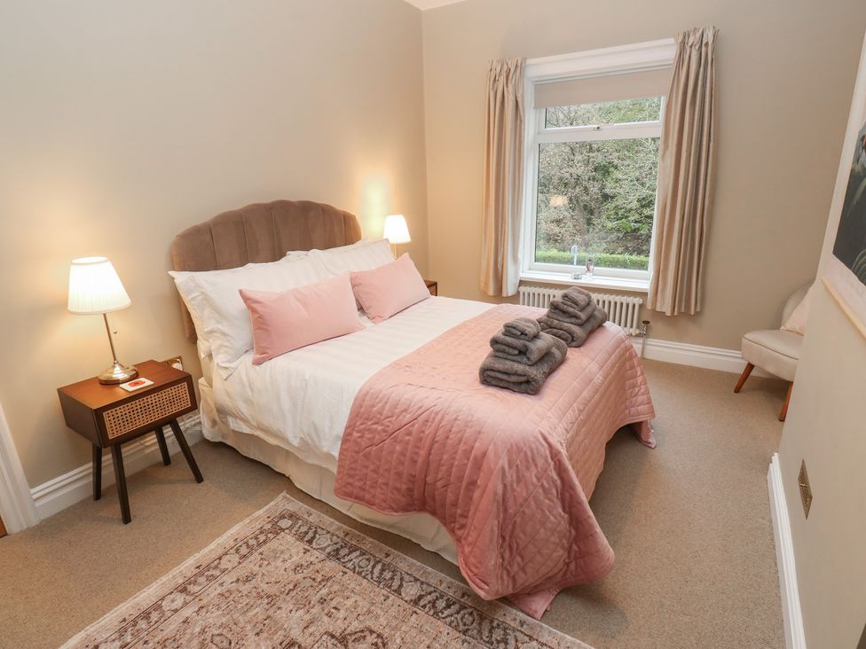 A bedroom with a bed and window at Fairfield House in Almondbury