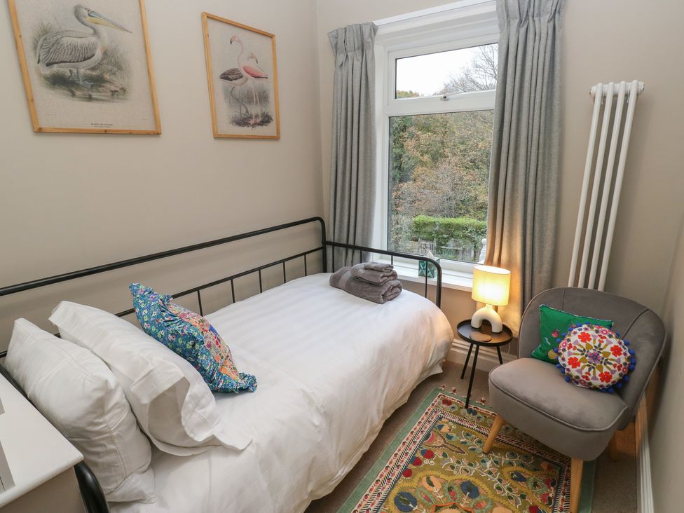 A bedroom with a bed and a chair at Fairfield House in Almondbury