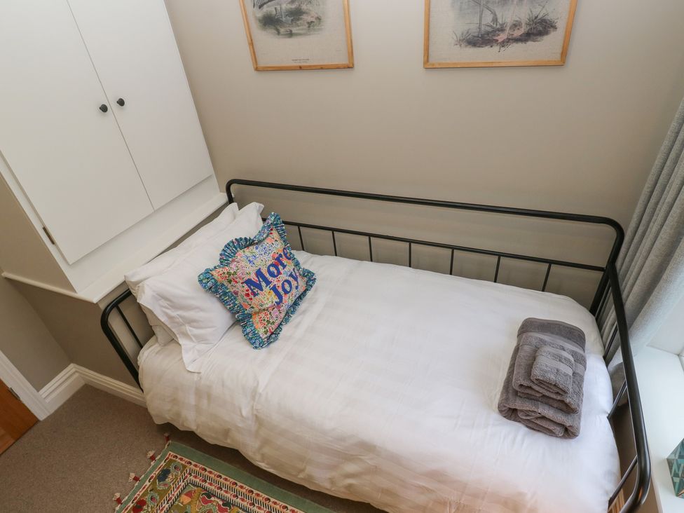 A bedroom with a bed and wardrobe at Fairfield House in Almondbury