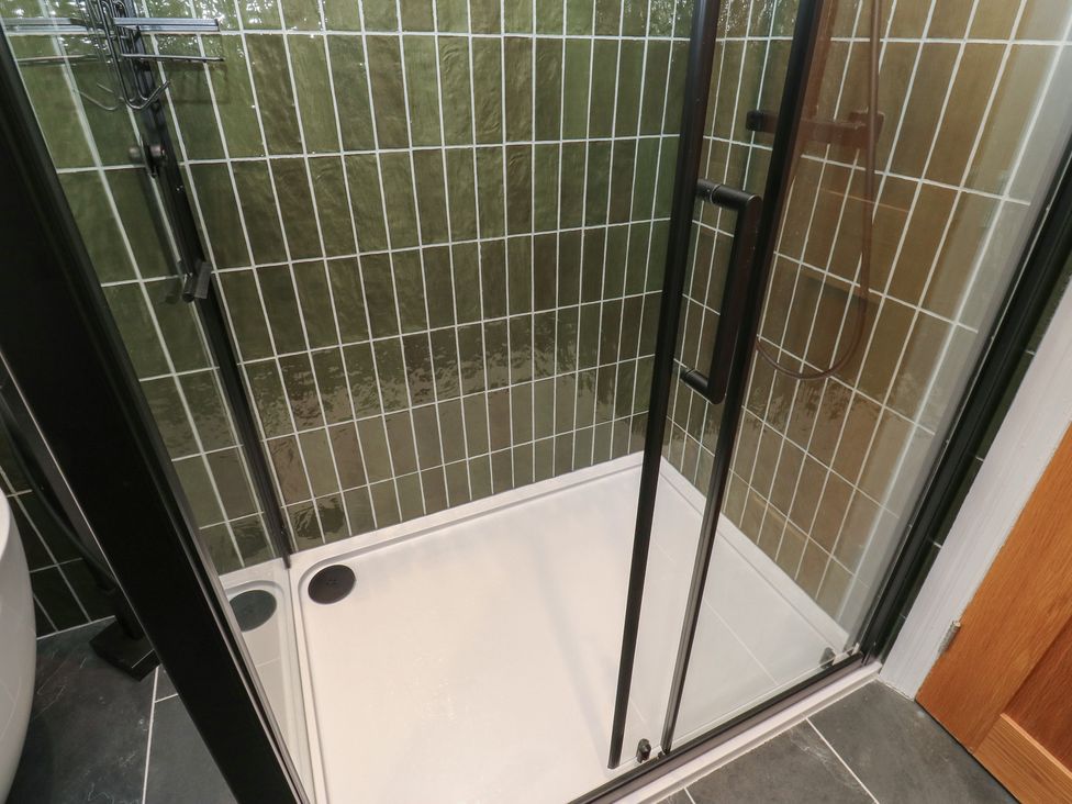 A shower enclosure with glass doors at Fairfield House Almondbury