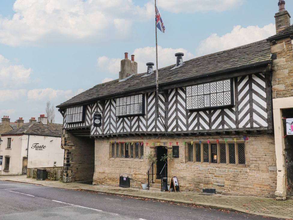 A building with a flag and decorative windows at Fairfield House in Almondbury
