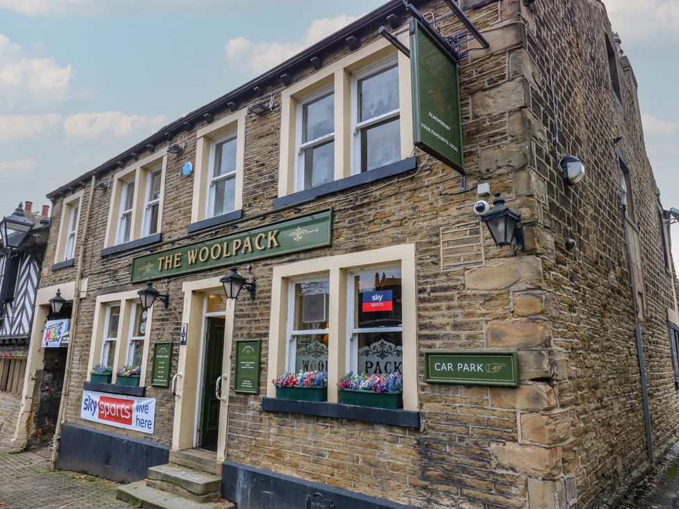 An exterior view of The Woolpack pub with a car park sign in Almondbury