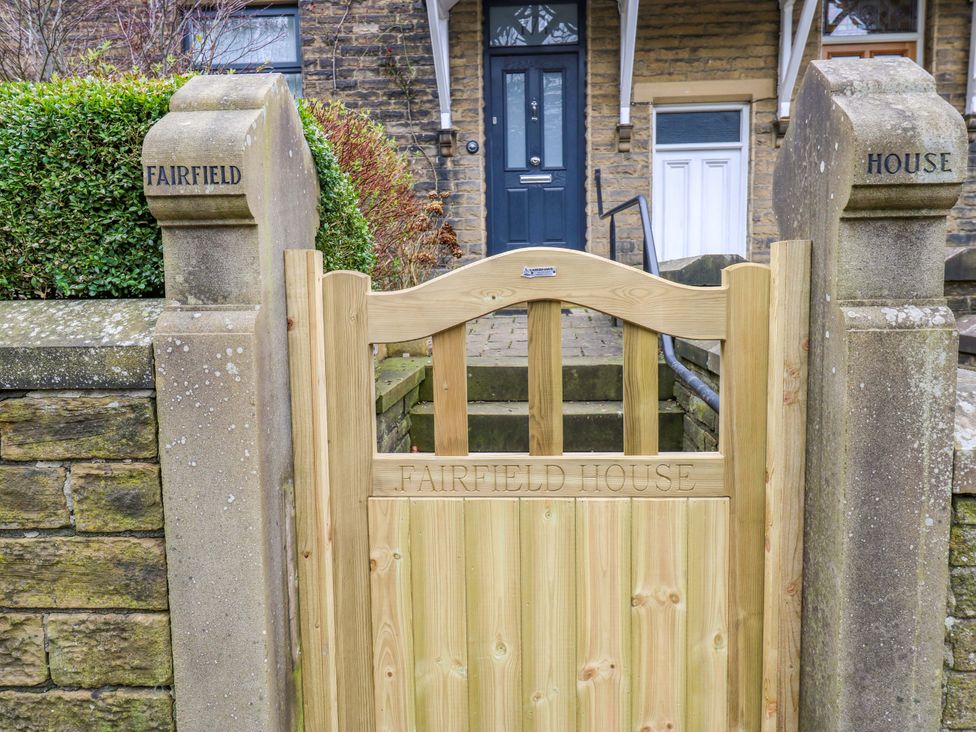 A wooden gate and stone pillars marking Fairfield House in Almondbury near Huddersfield