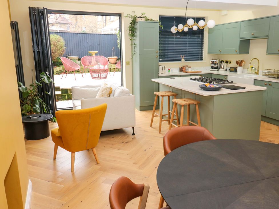 A kitchen with a countertop and stools at Fairfield House Almondbury near Huddersfield