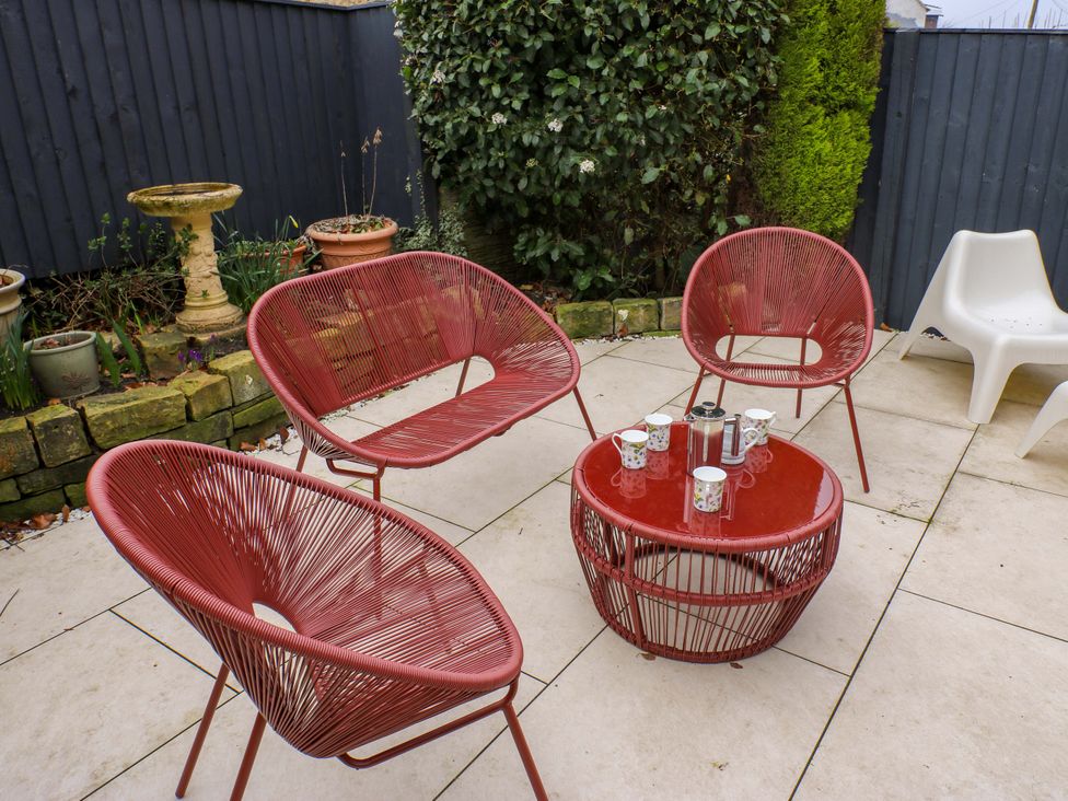 A garden with red chairs and a table at Fairfield House Almondbury near Huddersfield