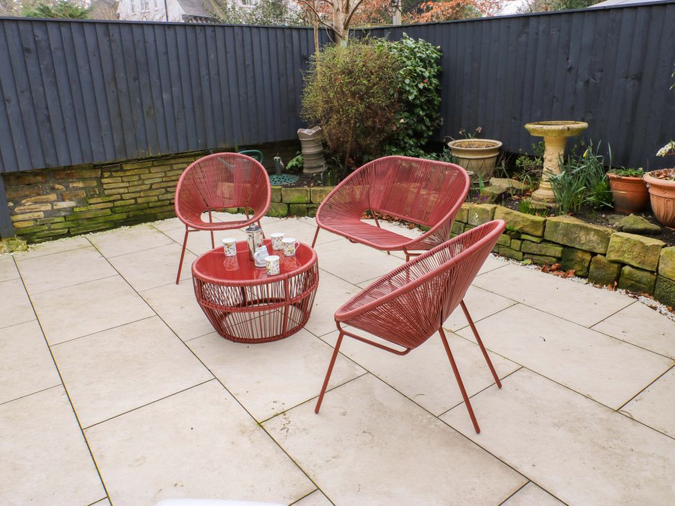 A garden with red chairs and a table at Fairfield House Almondbury near Huddersfield