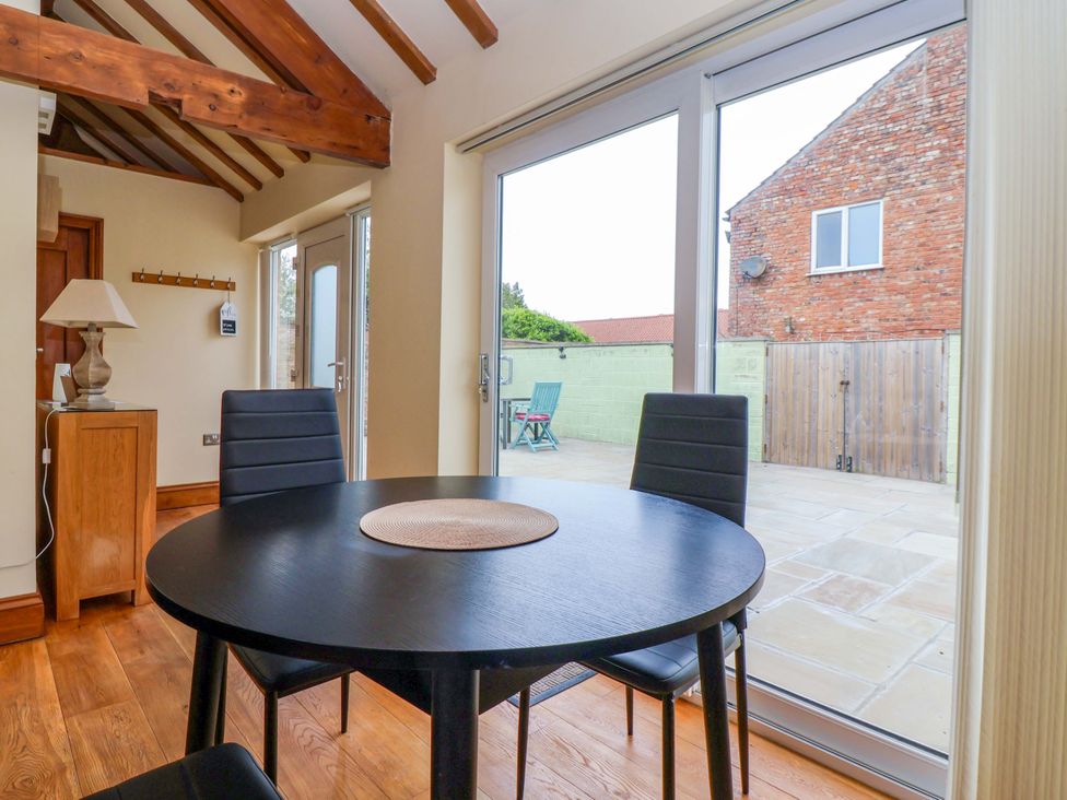 A dining room with a table and chairs at The Owl Barn Cottage 