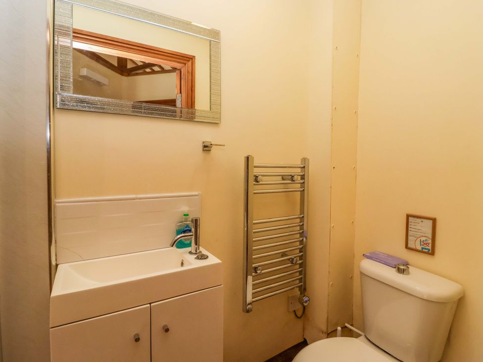 A bathroom featuring a sink, toilet, and towel rail at The Owl Barn Cottage