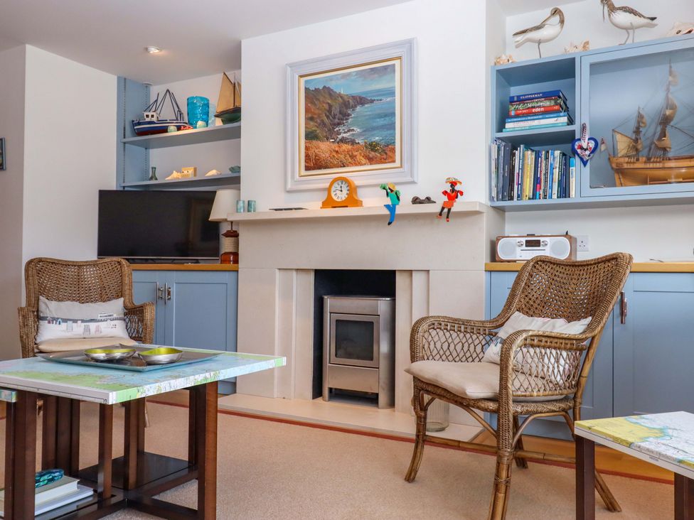 A living room with a fireplace and two chairs at 26 Dart Marina