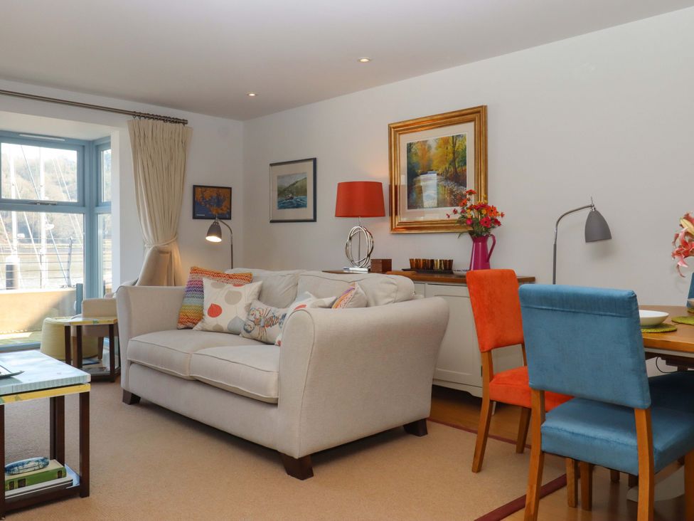 A living room with a sofa and dining area at 26 Dart Marina