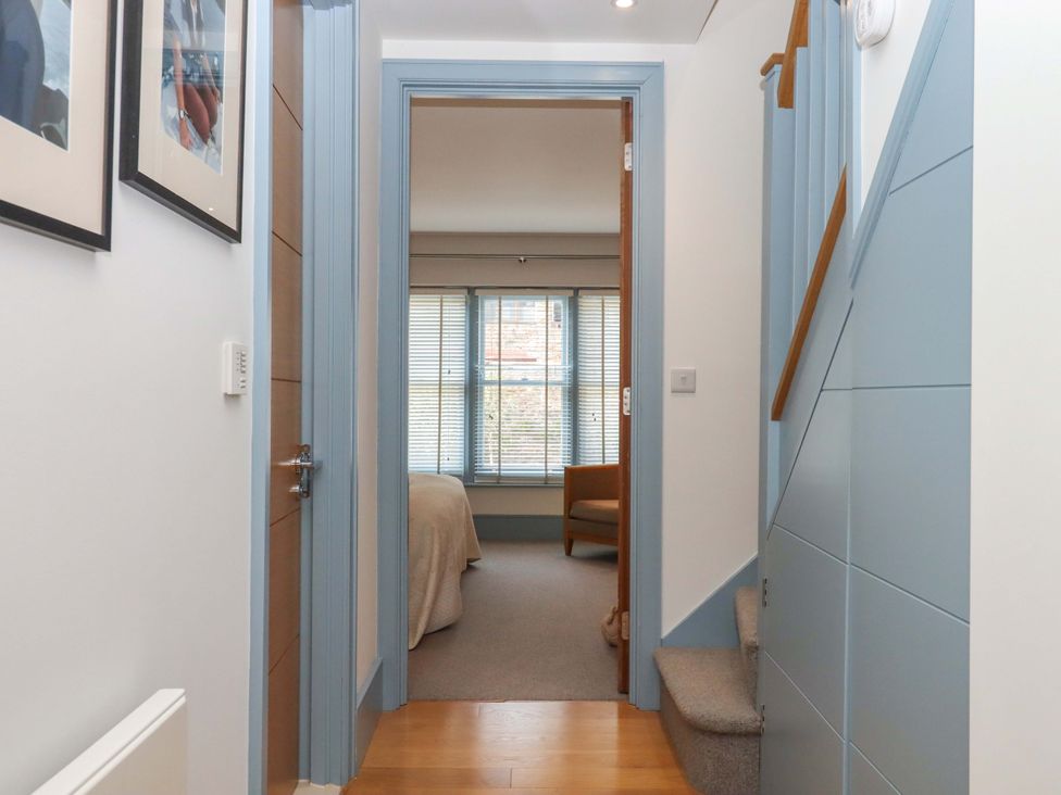 A hallway with stairs and a door leading to another room at 26 Dart Marina