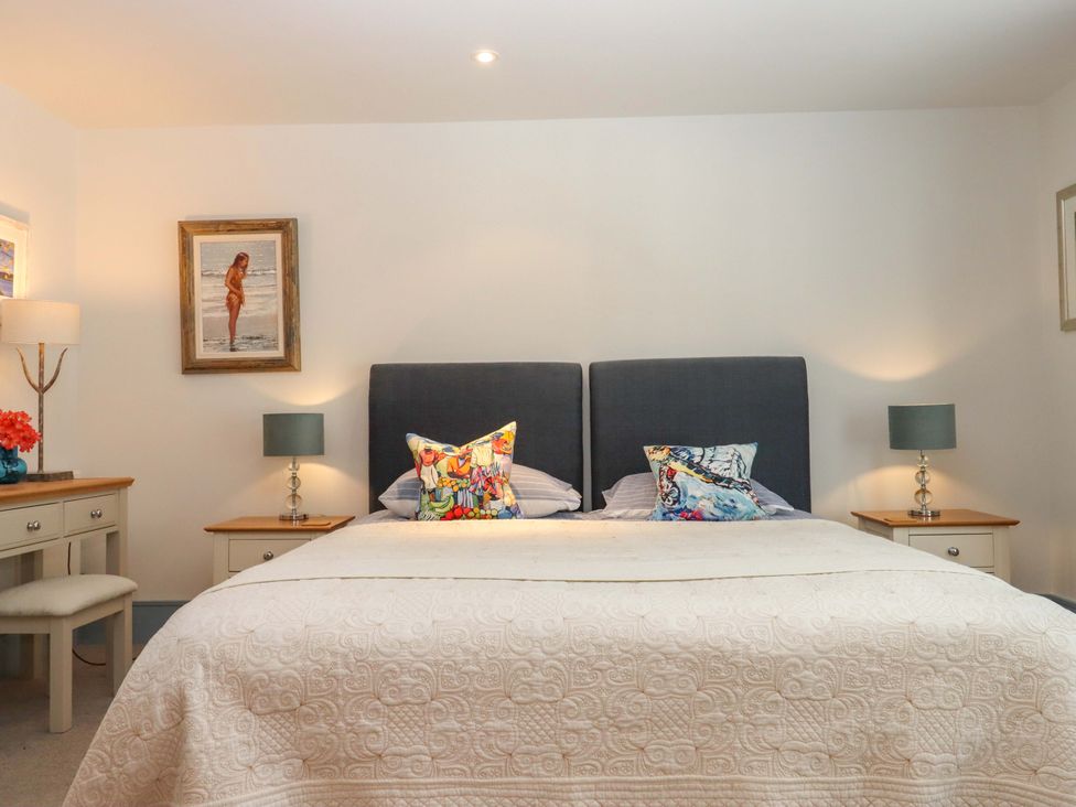 A bedroom with a bed and bedside tables at 26 Dart Marina