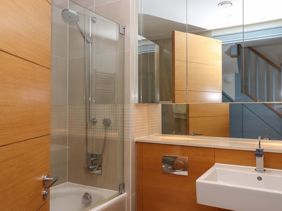 A bathroom with a shower, bathtub, and sink at 26 Dart Marina