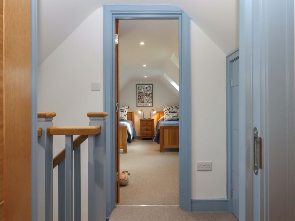A hallway leading to a bedroom with two beds and furniture at 26 Dart Marina