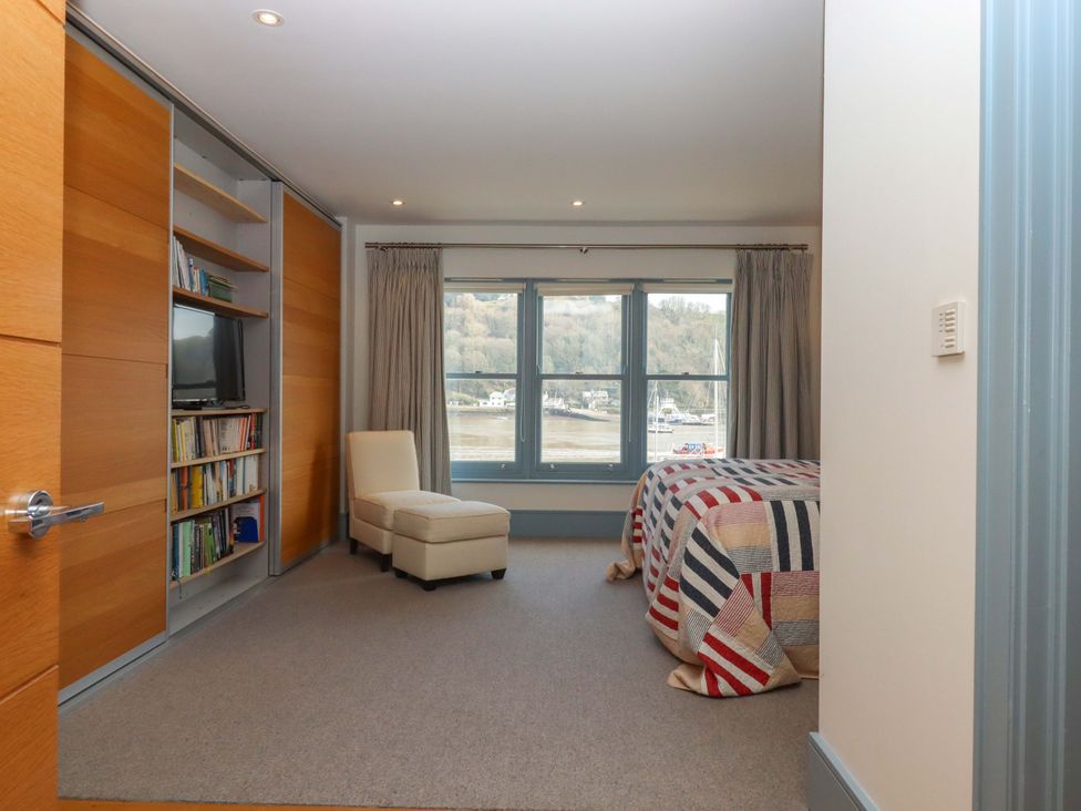 A bedroom with a chair and a bed at 26 Dart Marina