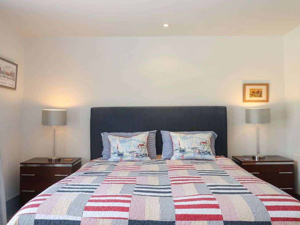 A bedroom with a bed and bedside tables at 26 Dart Marina