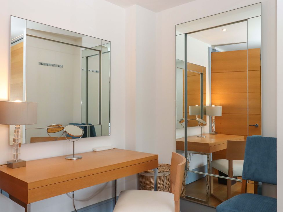 A dressing room with a vanity table and mirrors at 26 Dart Marina