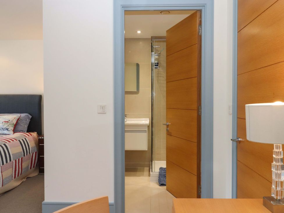 A bedroom with a bed and an adjoining bathroom at 26 Dart Marina