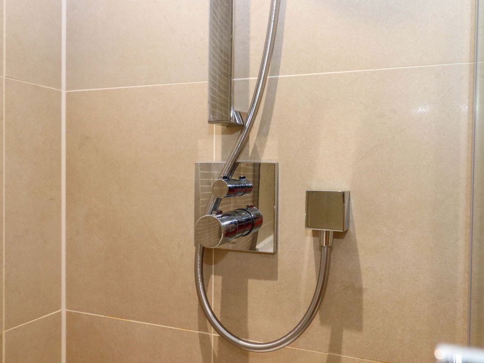 A shower control panel with a showerhead in a bathroom at 26 Dart Marina