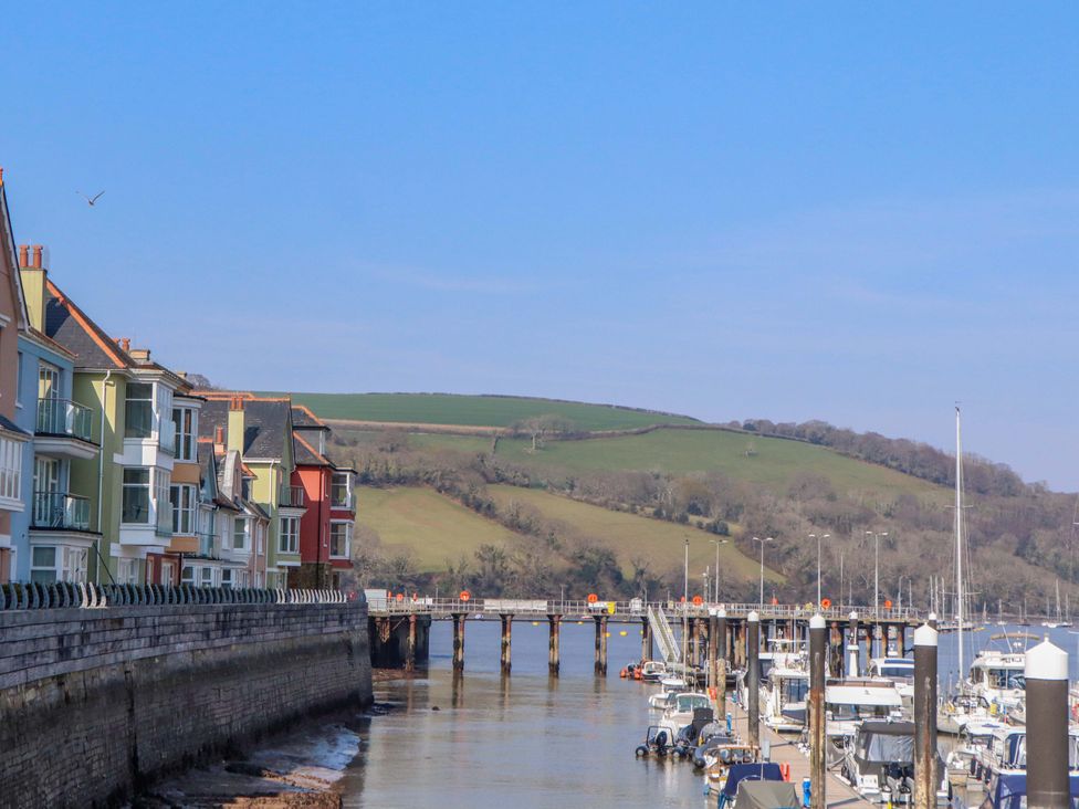 A view of houses along a waterfront with boats and a pier at 26 Dart Marina