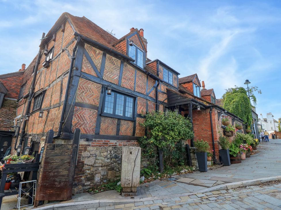 A house with brick walls and plants on the street at The Old House in Hamble